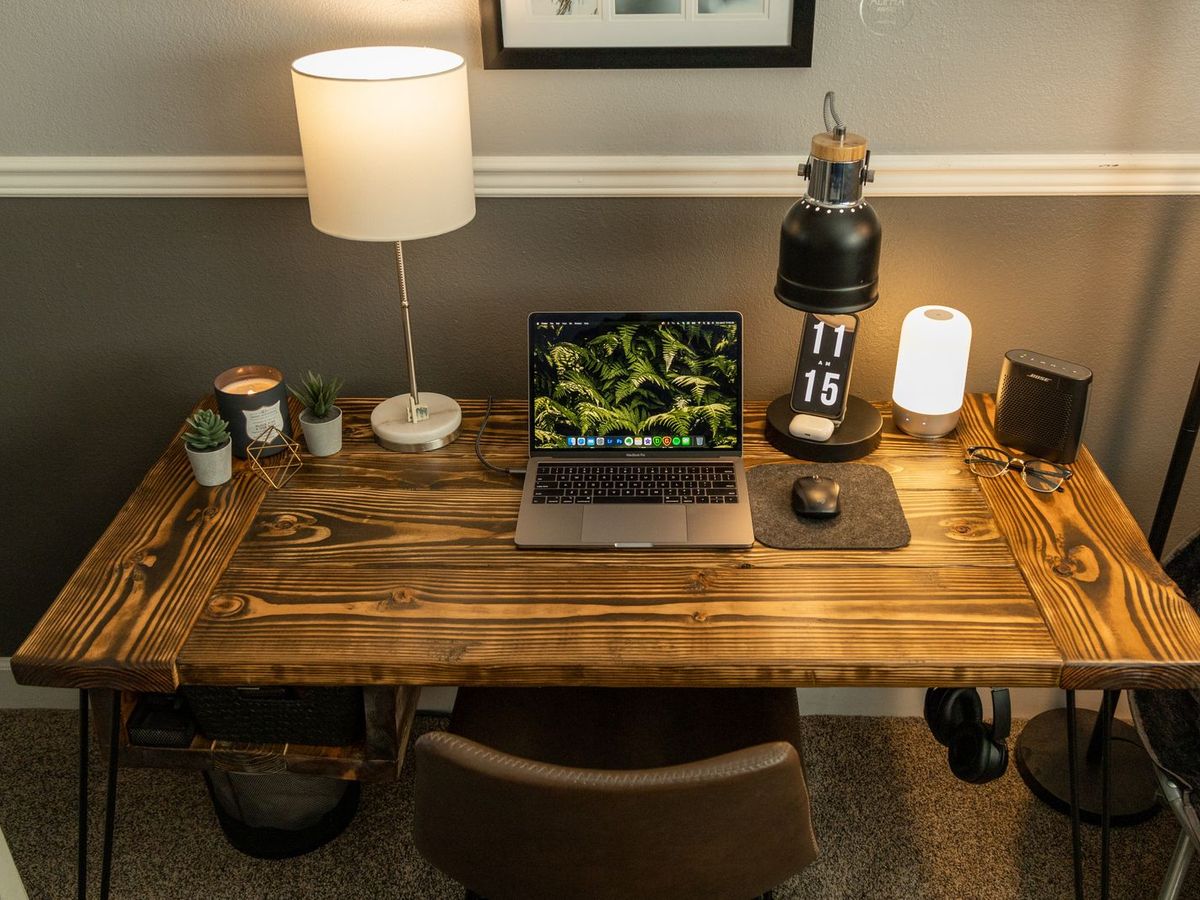 Bureau en bois avec ordinateur portable et lampe