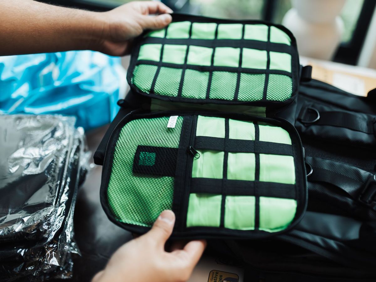Mains rangeant des cubes organisateurs dans une valise