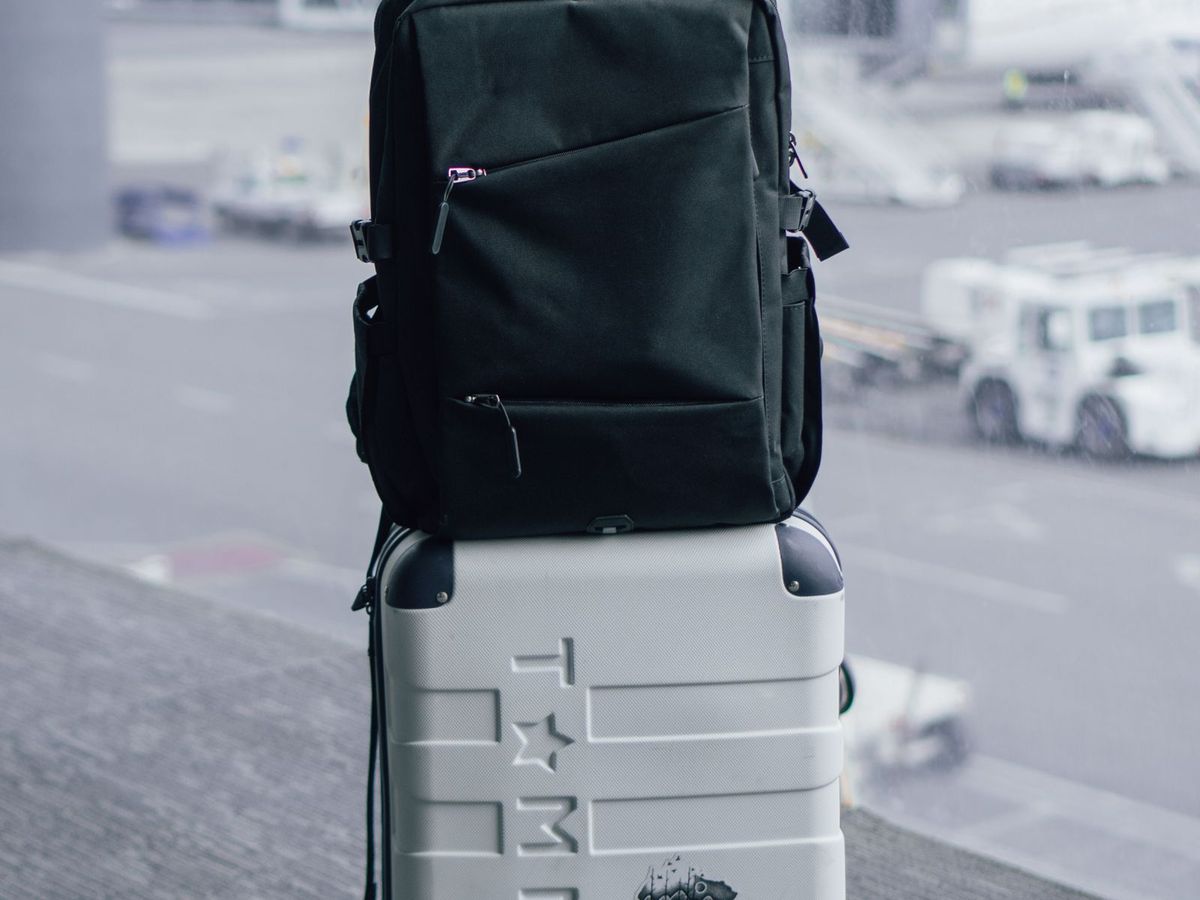 Sac à dos posé sur une valise à l’aéroport