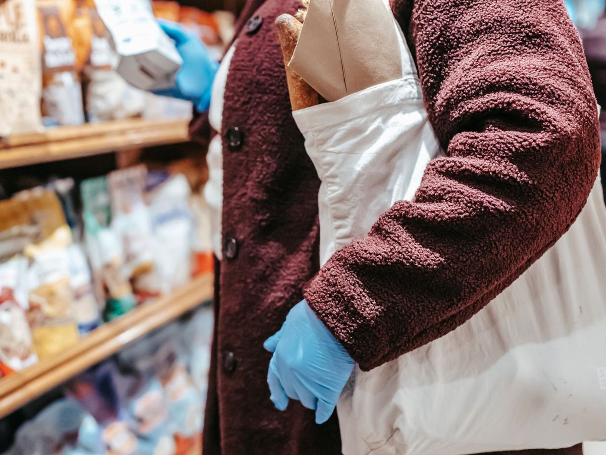 Personne portant un sac de courses réutilisable en magasin